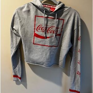 Official Coca-Cola gift shop language women’s crop hoodie.